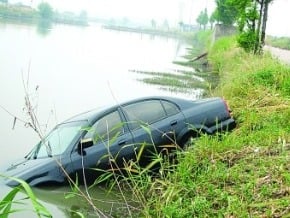 男子開著新車送女友 途中頻頻親吻沖入河中